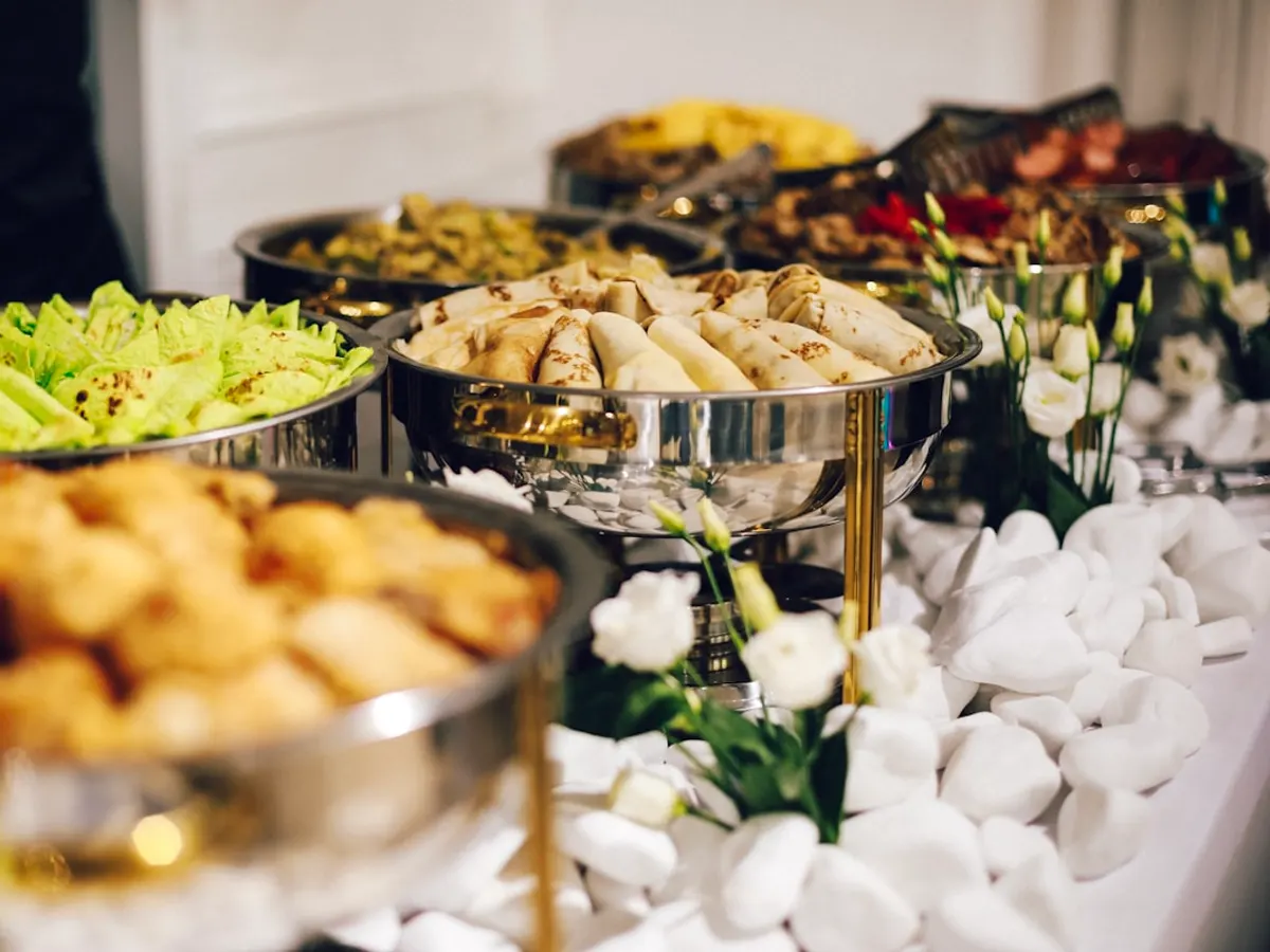 Catering website shown on a phone with event menu packages, food photos and a WhatsApp quote button (Gilgit)