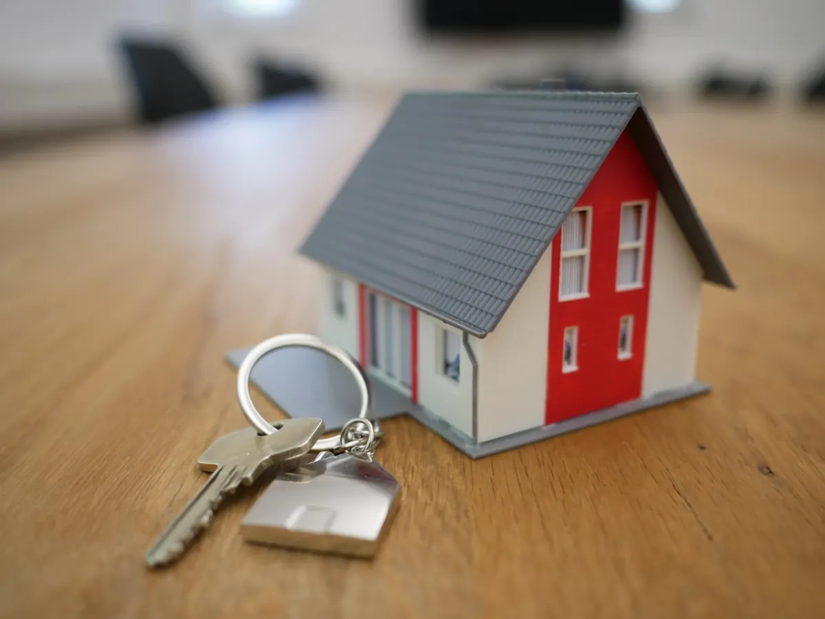 Real estate website shown on a laptop with property listings, photos and price details